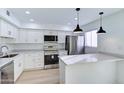 Contemporary kitchen featuring stainless steel appliances, white cabinetry, quartz countertops, and stylish pendant lighting at 6333 N 49Th Ave, Glendale, AZ 85301