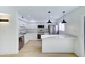 Modern kitchen featuring stainless steel appliances, sleek white cabinets, quartz countertops, and attractive pendant lighting at 6333 N 49Th Ave, Glendale, AZ 85301