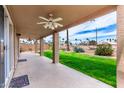 Covered patio overlooking green lawn with mature landscaping and a view of the surrounding neighborhood at 7118 E Juanita Ave, Mesa, AZ 85209