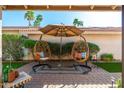 Inviting outdoor patio with hanging chairs, shade umbrella, and lush landscaping, perfect for relaxation at 8812 E Riviera Dr, Scottsdale, AZ 85260