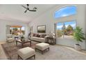 Bright living room featuring a vaulted ceiling, carpet, and several windows providing an abundance of natural light at 9039 W Wescott Dr, Peoria, AZ 85382