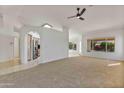 Open-concept living area featuring neutral paint, carpet flooring, a ceiling fan, and natural light at 9039 W Wescott Dr, Peoria, AZ 85382