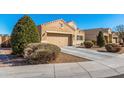 Well-maintained single-story home with a two-car garage, desert landscaping, and manicured shrubs at 9450 W Georgia Ave, Glendale, AZ 85305