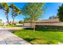Charming single-story home with a brick facade, lush lawn, and a two-car garage at 10103 W Saddle Ridge Dr, Sun City, AZ 85373