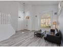 Bright, open living room with wood flooring, modern lighting, and stylish shutters at 1331 E Voltaire Ave, Phoenix, AZ 85022