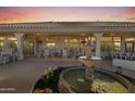 Spacious covered patio featuring a water feature, ceiling fans, and ample seating at 13514 W Wagon Wheel Dr, Sun City West, AZ 85375