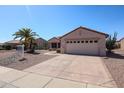 Single story home with low maintenance desert landscaping, mature palm trees, and a two car garage at 15561 W Vista Grande Ln, Surprise, AZ 85374