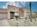 Inviting single-story home with desert landscaping, rock accents, and an attached garage at 17234 E Sunscape Dr, Fountain Hills, AZ 85268