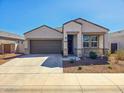 Beautiful single Gathering home showcasing desert landscaping, a spacious driveway, and covered porch at 18809 W Wilson St, Buckeye, AZ 85326