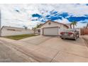 Single-story home with a spacious driveway, two-car garage, and lawn area at 2327 W Rockwell Ct, Chandler, AZ 85224