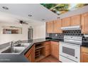 Traditional kitchen with dark countertops, oak cabinets, and modern appliances at 2327 W Rockwell Ct, Chandler, AZ 85224