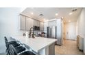 Modern kitchen with stainless steel appliances, a breakfast bar, and gray cabinets at 2511 W Queen Creek Rd # 479, Chandler, AZ 85248