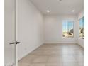 Inviting, light-filled living room with tile floors and large windows offering picturesque neighborhood views at 26535 W Mcrae Dr, Buckeye, AZ 85396