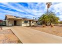 Inviting single-story home with a long driveway and desert landscaping, plus a mature palm tree at 280 W 23Rd Ave, Apache Junction, AZ 85120