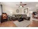 Comfortable living room with hardwood floors, a ceiling fan, a sectional sofa, and a view to the kitchen at 280 W 23Rd Ave, Apache Junction, AZ 85120