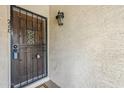 Close-up showcasing a wood front door with a black security gate and a vintage-style outdoor light fixture at 3102 E Clarendon Ave # 210, Phoenix, AZ 85016