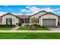 Beautiful single-story home featuring a lush green lawn, charming landscaping, and a convenient two-car garage at 3483 E Bloomfield Pkwy, Gilbert, AZ 85296