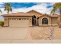 Charming single-story home showcasing a well-maintained yard, palm trees, and a two-car garage at 3690 N 150Th Ave, Goodyear, AZ 85395