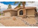 Well-maintained home features desert landscaping, a tile roof, a two-car garage, and a palm tree at 3690 N 150Th Ave, Goodyear, AZ 85395