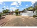 Charming exterior view of the home with a circular driveway and attached garage at 4010 E Montebello Ave, Phoenix, AZ 85018