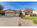 Inviting single-story home with a spacious three-car garage, green lawn, and desert landscaping at 4614 W Fallen Leaf Ln, Glendale, AZ 85310