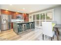 Bright kitchen featuring a stainless steel fridge, wood cabinetry, granite counters and an island with barstool seating at 4950 N Miller Rd # 122, Scottsdale, AZ 85251