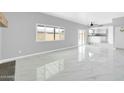 Spacious living room featuring sleek floors, a large window, and access to the backyard at 5228 W Ironwood Dr, Glendale, AZ 85302