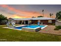 A backyard featuring a swimming pool, lounge chairs, and a covered patio, perfect for outdoor relaxation at 5501 N 1St St, Phoenix, AZ 85012