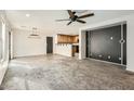 Open-concept living room flows into kitchen; neutral color palette with bright white trim and a dark accent wall at 5828 E Hampton Ave, Mesa, AZ 85206