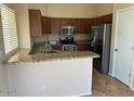 Kitchen features stainless appliances, tile floor, breakfast bar and tile countertops at 8179 W Clara Ln, Peoria, AZ 85382