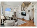 Bright living room with high ceilings, large windows, hardwood floors, and a modern staircase at 9264 E Hillery Way, Scottsdale, AZ 85260