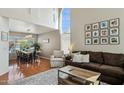 Open-concept living and dining area with hardwood floors, large windows, and stylish decor at 9264 E Hillery Way, Scottsdale, AZ 85260