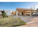 Inviting single-story home featuring a covered carport, well-maintained landscaping, and a charming gated courtyard at 1005 W Berridge Ln, Phoenix, AZ 85013