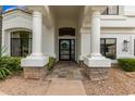 Inviting entrance with stone tile, stately white columns, and decorative door at 1152 W Sunrise Pl, Chandler, AZ 85248