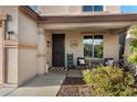 Inviting front porch with dark wood door, seating, and decorative accents at 12132 W Daley Ln, Sun City, AZ 85373