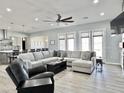 Open-concept living room with a large sectional sofa, ceiling fan, and modern design at 12204 W Black Hawk Rd, Casa Grande, AZ 85194