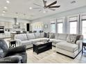 Bright living room showcasing a large sectional, ceiling fan, and contemporary accents at 12204 W Black Hawk Rd, Casa Grande, AZ 85194