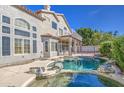 Backyard oasis showcasing a sparkling pool with rock features, lush landscaping, and the home's exterior at 13236 N 13Th St, Phoenix, AZ 85022