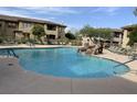 Community pool featuring a waterfall, surrounding lounge chairs, and lush landscaping at 16800 E El Lago Blvd # 2062, Fountain Hills, AZ 85268