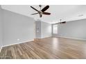 Bright living room featuring wood-style floors and ceiling fans at 18033 W Carmen Dr, Surprise, AZ 85388