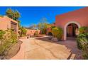 Private courtyard with decorative stone pavers, mature landscaping, and an arched entrance feature at 22005 N 86Th Ave, Peoria, AZ 85383