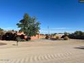 A charming single-story home with mature tree, circular driveway, and an American flag at 22005 N 86Th Ave, Peoria, AZ 85383