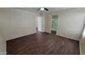 Bright bedroom with wood-look floors, ceiling fan, and neutral paint, adjacent to a bathroom for comfortable living at 22067 W Cantilever St, Buckeye, AZ 85326