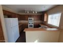 Well-lit kitchen featuring ample counter space, white appliances, and wood cabinetry at 22067 W Cantilever St, Buckeye, AZ 85326