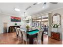 Bright dining room featuring a billiards table and sliding glass doors to access outdoor patio at 23219 N 145Th Dr, Sun City West, AZ 85375