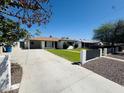 Single-story home with attached carport, large driveway, and mature landscaping at 2450 E Clarendon Ave, Phoenix, AZ 85016
