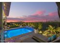 Stunning pool area with elegant landscaping, inviting lounge chairs, and ambient lighting for relaxed outdoor living at 26716 W Ponderosa Ln, Buckeye, AZ 85396