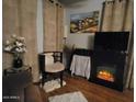 Comfortable living area featuring a fireplace, a TV, and soft, neutral-toned curtains at 306 S Recker Rd # 212, Mesa, AZ 85206