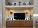 Built-in entertainment center with display niche and decorative items at 3301 S Goldfield Rd # 4025, Apache Junction, AZ 85119