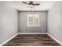 An empty bedroom with a ceiling fan, hardwood floors, and a window at 36076 N Vidlak Dr, San Tan Valley, AZ 85143